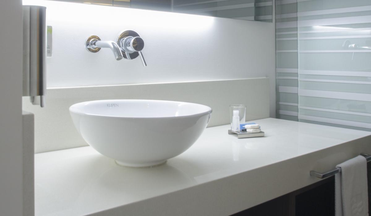 Lavabo elegante con iluminación suave en baño del Hotel Casablanca Cúcuta. Lavabo moderno con iluminación suave y espejo en baño del Hotel Casablanca Cúcuta.