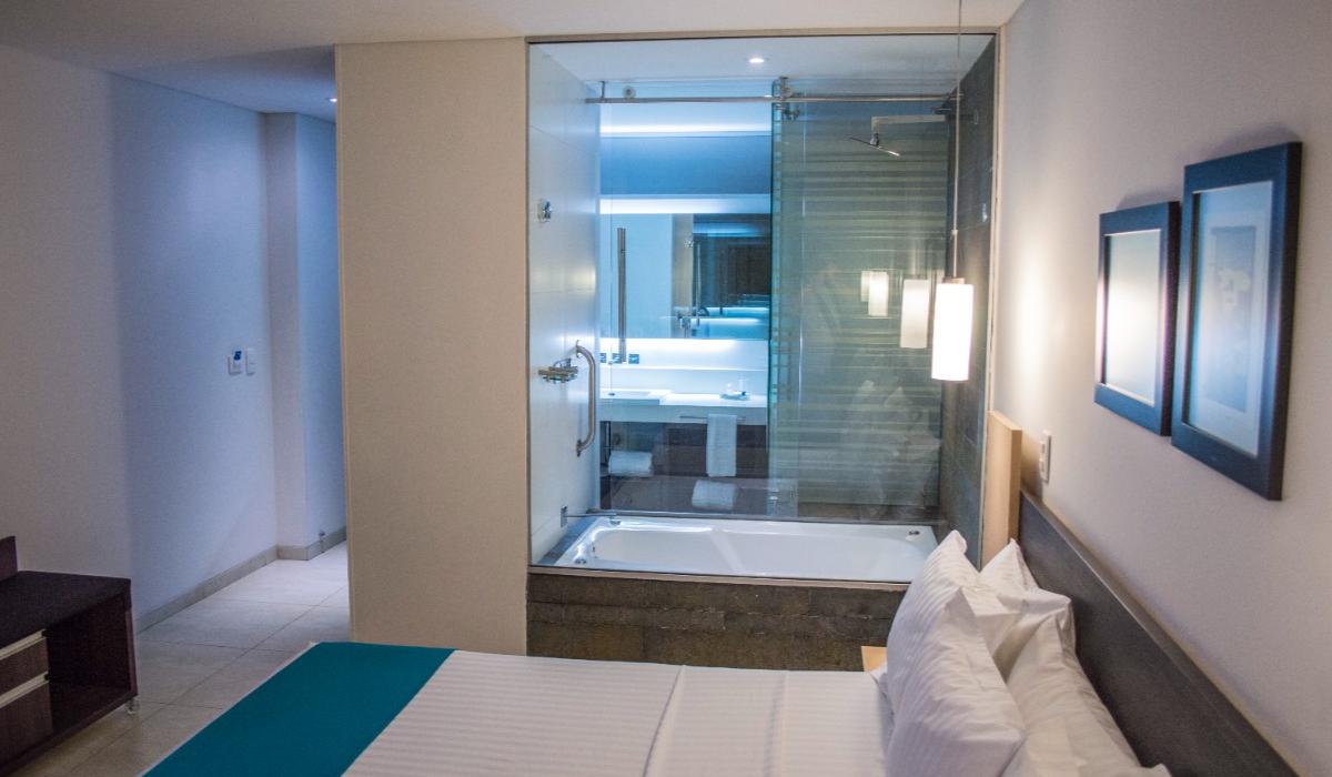 Habitación moderna con cama king y baño con vidrio en Hotel Casablanca Cúcuta. Habitación con cama king junto a baño con vidrio en Hotel Casablanca Cúcuta.